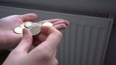 woman hold money near the heating radiator. Rising utility bills. A crisis. Expensive heating bill. High quality 4k footage