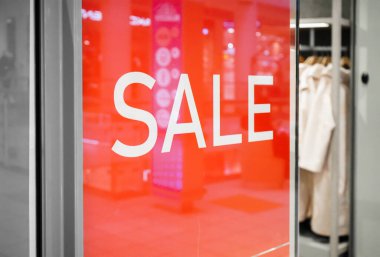 The inscription Sale at the entrance to the store on a red background.