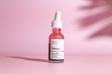 Warszaw, Poland - May, 2023: The Ordinary skincare brand by Deciem. Bottles with red peeling and solutions. Closeup of The Ordinary Peeling on pink background clipart