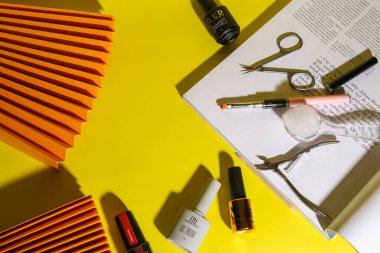 Varşova, Polonya - Mayıs 2023: Sarı parlak arkaplanda jöle ve manikür aletleri. Renk eşleştirme, kuaförde tırnak tasarımı, manikür hizmetleri. Güzellik salonu, güzellik salonu.