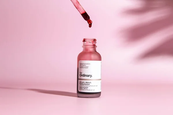 stock image Warszaw, Poland - May, 2023: The Ordinary skincare brand by Deciem. Bottles with red peeling and solutions. Closeup of The Ordinary Peeling on pink background