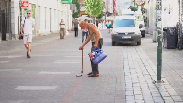 ワルシャワ ポーランド 2023年8月23日 ホームレスの男性が街の中心部の通りを歩き 缶の袋を持って歩きます ポーランドではホームレス 高品質の4K映像 — ストック動画