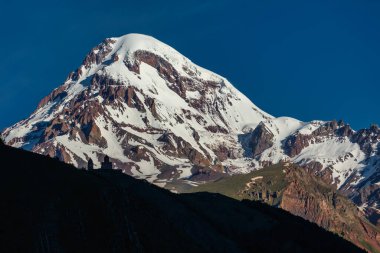 Gürcistan 'ın Stepantsminda köyü yakınlarındaki Gergeti Trinity Kilisesi, Kazbek Dağı veya Kazbegi Dağı' nın 2170 metre altında.,