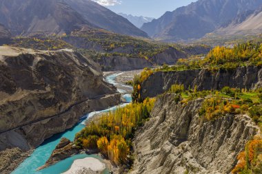 Hunza Nehri 'nin sonbahar manzaralı mavi suları, arka planda sıradağlar, Hunza, Pakistan.