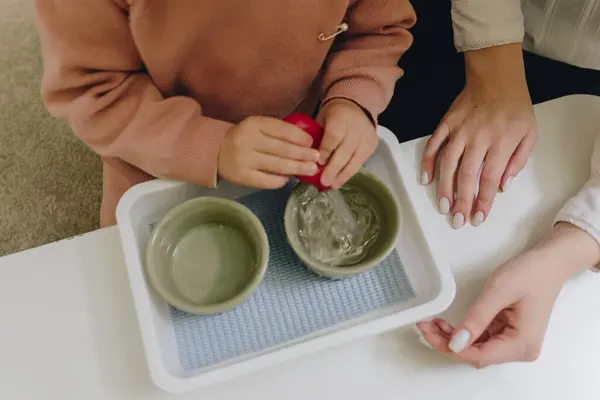 Montessori sınıfında su ve pipetle çalışan bir çocuk. Yüksek kalite fotoğraf