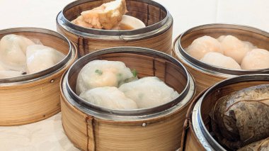 Bambu sepetlerinde servis edilen ve geleneksel Çin Dim Sum mutfağının sergilendiği buharda pişirilmiş lezzetlerin fotoğrafı. Çin Yeni Yılı, Ay Yılı, Dim Sum, Hamur tatlısı, Özgünlük, Kutlama