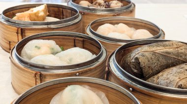 Bambu sepetlerinde servis edilen ve geleneksel Çin Dim Sum mutfağının sergilendiği buharda pişirilmiş lezzetlerin fotoğrafı. Çin Yeni Yılı, Ay Yılı, Dim Sum, Hamur tatlısı, Özgünlük, Kutlama