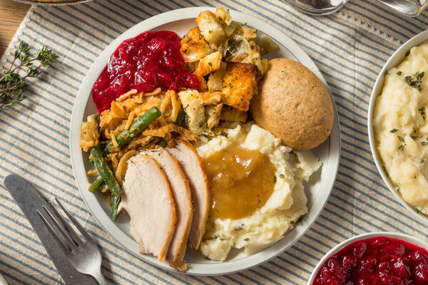 Homemade Thanksgiving Turkey Dinner with Potatoes Gravy Cranberry and Beans