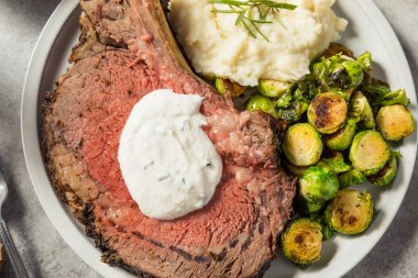 Homemade Standing Prime Rib Beef Roast with Horseradish Sauce and Potatoes clipart