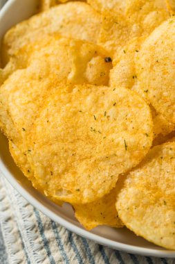 Homemade Flavored Dill Pickle Potato Chips in a Bowl to Eat