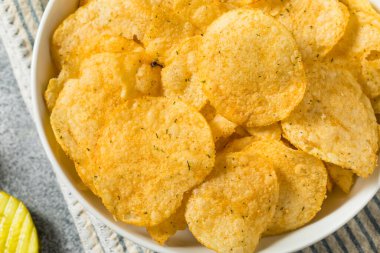 Homemade Flavored Dill Pickle Potato Chips in a Bowl to Eat
