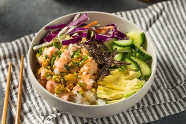 Ev yapımı Asya susam somonu kasesi, yanında pirinç ve salatalık.