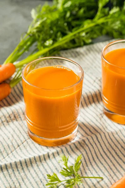 冷保鲜生胡萝卜汁准备在玻璃杯中饮用 — 图库照片