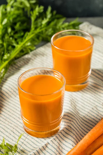 冷保鲜生胡萝卜汁准备在玻璃杯中饮用 — 图库照片