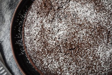 Fırında çikolatalı zeytinyağlı kek ve pudra şekeri.