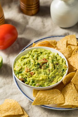 Ev yapımı avokado guacamole ve domatesli tortilla cipsi.