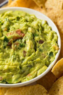 Ev yapımı avokado guacamole ve domatesli tortilla cipsi.