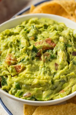 Ev yapımı avokado guacamole ve domatesli tortilla cipsi.