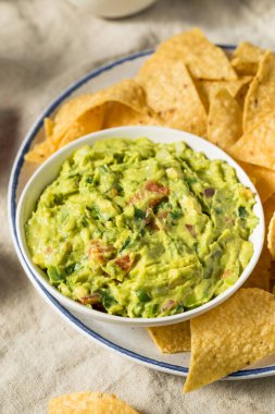 Ev yapımı avokado guacamole ve domatesli tortilla cipsi.