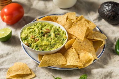 Ev yapımı avokado guacamole ve domatesli tortilla cipsi.