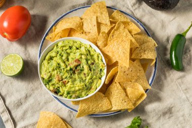 Ev yapımı avokado guacamole ve domatesli tortilla cipsi.