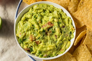 Ev yapımı avokado guacamole ve domatesli tortilla cipsi.