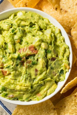 Ev yapımı avokado guacamole ve domatesli tortilla cipsi.