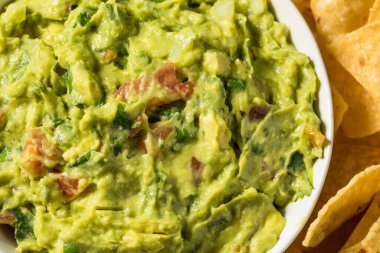 Ev yapımı avokado guacamole ve domatesli tortilla cipsi.