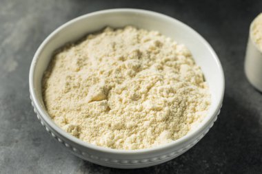 Bir kepçedeki organik sağlıklı vanilyalı süt tozu.