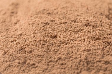 Bir kepçenin içindeki organik çikolatalı süt proteini tozu.