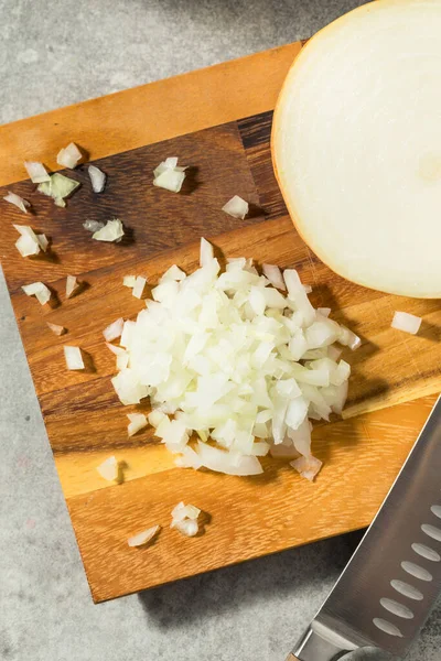 Raw Organic Yellow Diced Onions on a Cutting Board