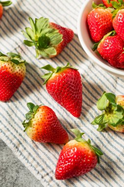 Bir kâse içinde organik çiğ kırmızı çilek.