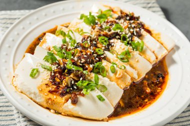 Acı biber soslu Asya baharatlı ipek tofu ve taze soğan.