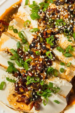 Acı biber soslu Asya baharatlı ipek tofu ve taze soğan.