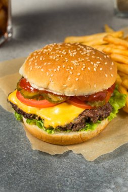 Fast Food Cheeseburger ve patates kızartması ile marul domates ve turşu.