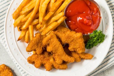 Patates kızartması ve ketçaplı sağlıklı çocuk dinozor tavuk nuggetları.