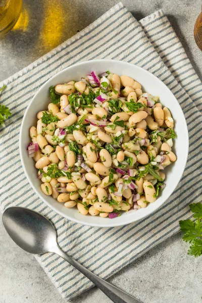 Bitki ve soğanlı sağlıklı soğuk beyaz fasulye yaz salatası.