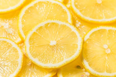 Kesme tahtasındaki organik, sarı dilimlenmiş limonlar.