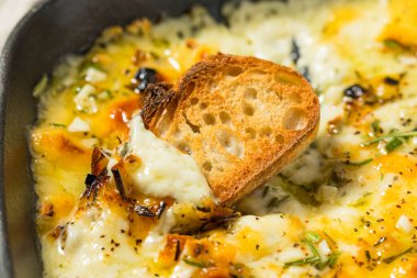 Sıcak fırınlanmış Fontina peyniri, bitkilerle batırılmış sarımsak ve kızarmış ekmek.