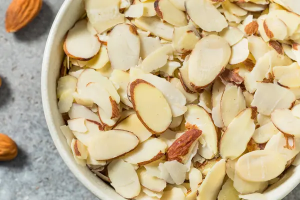 Pişirmek için bir kâsede çiğ organik beyaz dilimlenmiş badem.