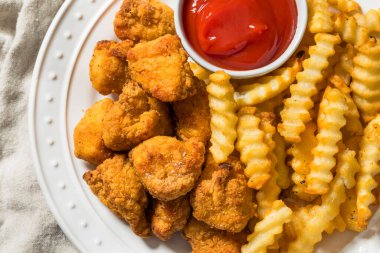 Organik sağlıklı kızarmış tavuk nugget ve ketçaplı patates kızartması.