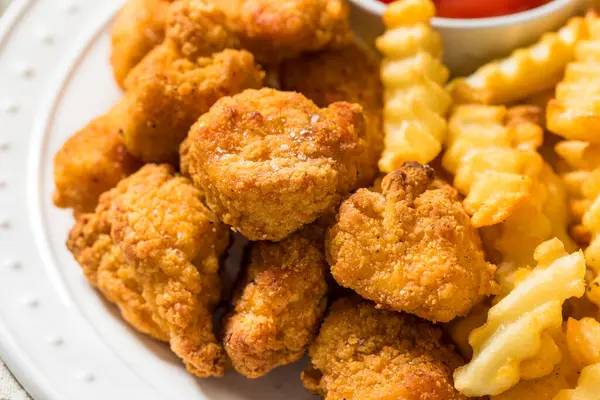 Organik sağlıklı kızarmış tavuk nugget ve ketçaplı patates kızartması.