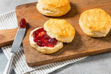 Kahvaltı için tereyağlı bisküvi ve çilekli reçel.