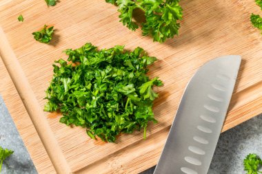 Raw Green Organic Minced Parsley on a Cutting Board
