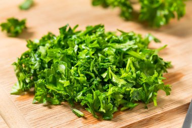 Raw Green Organic Minced Parsley on a Cutting Board