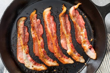 Greasy Cooked Thick Cut Bacon in a Skillet Pan