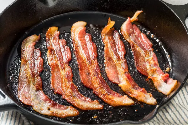 Greasy Cooked Thick Cut Bacon in a Skillet Pan