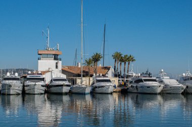 Marine port Cogolin with yachts in harbor palm trees behind day tme