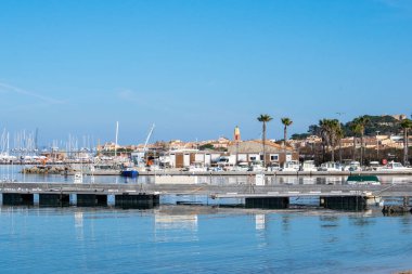 Saint Tropez view from far away with palm trees water and blue sky in day time