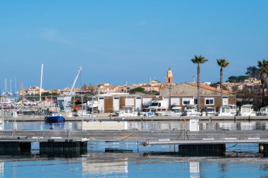 Saint Tropez view from far away with palm trees water and blue sky in day time